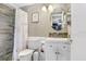Well-lit bathroom featuring a patterned shower curtain, vanity with storage, modern faucet and wall decor at 2119 Sugarbush Dr, Holiday, FL 34690