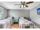 Bright and airy bedroom features two twin beds, a ceiling fan, and laminate flooring, a cozy retreat at 2119 Sugarbush Dr, Holiday, FL 34690