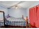 Cozy bedroom featuring a ceiling fan and a bed with blue striped bedding and wood frame at 2119 Sugarbush Dr, Holiday, FL 34690