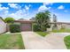Well-maintained single-story home with mature trees, a circular driveway, and a unique arched entryway at 2119 Sugarbush Dr, Holiday, FL 34690