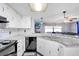 Well-lit kitchen featuring stainless steel appliances, white cabinetry, and tiled backsplash at 2119 Sugarbush Dr, Holiday, FL 34690