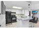 Bright kitchen with granite countertops, white cabinets, and stainless steel appliances at 2119 Sugarbush Dr, Holiday, FL 34690