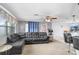 Comfortable living room features a large sectional sofa, ceiling fan, large windows and view of the kitchen bar at 2119 Sugarbush Dr, Holiday, FL 34690
