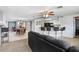 Bright living room featuring an open floor plan with kitchen bar, dining area, ceiling fan and neutral carpeting at 2119 Sugarbush Dr, Holiday, FL 34690