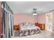 Cozy main bedroom with pink walls, decorative bedding, ceiling fan, and doorway to the en-suite bathroom at 2119 Sugarbush Dr, Holiday, FL 34690