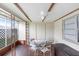 Enclosed sunroom with a table, four chairs, ceiling fan and decorative metalwork at 2119 Sugarbush Dr, Holiday, FL 34690