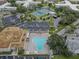 Aerial view of community pool, parking, and lush landscaping of the condo complex at 2466 Ecuadorian Way # 32, Clearwater, FL 33763