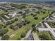 Expansive community grounds with lush green spaces, a pond, and mature trees in aerial view at 2466 Ecuadorian Way # 32, Clearwater, FL 33763