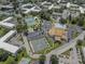 Aerial view showcasing the community pool, tennis courts, parking, and lush landscaping of the condo complex at 2466 Ecuadorian Way # 32, Clearwater, FL 33763