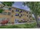 Exterior view of a multi-unit apartment building, highlighting the backyard and individual AC units at 2466 Ecuadorian Way # 32, Clearwater, FL 33763