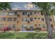 View of the exterior of the condo building with lush green space and a patio at 2466 Ecuadorian Way # 32, Clearwater, FL 33763