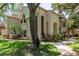 Exterior view of the house showcasing lush landscaping, tall windows and a brick-paved pathway at 247 Los Prados Dr # 1123, Safety Harbor, FL 34695