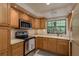 Well-lit kitchen features wood cabinets, stainless steel appliances, and a bright window view at 247 Los Prados Dr # 1123, Safety Harbor, FL 34695