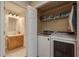 Laundry room with washer, dryer, shelving and a view of an adjacent bathroom at 247 Los Prados Dr # 1123, Safety Harbor, FL 34695
