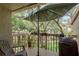 Cozy covered patio featuring wood flooring, comfortable seating, and a lush green view at 247 Los Prados Dr # 1123, Safety Harbor, FL 34695