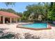 Community pool with a spacious deck, lounge chairs, and shade trees for relaxing by the water at 247 Los Prados Dr # 1123, Safety Harbor, FL 34695