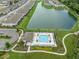 Aerial shot of the community pool and surrounding townhomes bordering the large pond at 26082 Woven Wicker Bnd, Lutz, FL 33559