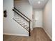 The home's entryway has wood-look floors and staircase with white risers and a white door at 26082 Woven Wicker Bnd, Lutz, FL 33559