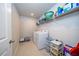 Bright laundry room with a full size washer and dryer and convenient shelving for storage at 26082 Woven Wicker Bnd, Lutz, FL 33559