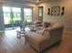 Living room showcases a view of the pond and patio with glass sliding doors at 26082 Woven Wicker Bnd, Lutz, FL 33559