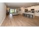 Open-concept living space with modern gray tones, wood-look flooring and a kitchen island at 26082 Woven Wicker Bnd, Lutz, FL 33559