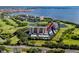 An aerial shot captures the condo building, nestled amidst lush greenery and a golf course near serene lake waters at 2621 Cove Cay Dr # 309, Clearwater, FL 33760