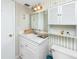 Bathroom with vanity, mirror, storage cabinet, and decorated wallpaper at 2621 Cove Cay Dr # 309, Clearwater, FL 33760
