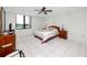 Bright bedroom features a ceiling fan, tile flooring, and a window with a view at 2621 Cove Cay Dr # 309, Clearwater, FL 33760