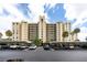 The exterior view of the condo building highlights ample parking and meticulous landscaping at 2621 Cove Cay Dr # 309, Clearwater, FL 33760