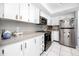 Well-lit kitchen features white cabinets, stainless steel appliances, and tile floors at 2621 Cove Cay Dr # 309, Clearwater, FL 33760