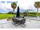 Inviting outdoor seating area with an umbrella table, fire pit and picturesque views of a golf course and pond at 2621 Cove Cay Dr # 309, Clearwater, FL 33760