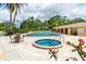 Community pool area featuring a pool, spa, lounge chairs, and seating, surrounded by lush greenery at 2621 Cove Cay Dr # 309, Clearwater, FL 33760