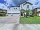 Charming two-story home with a brick driveway, lush lawn, and a beautiful palm tree accenting the front yard at 2798 Hilliard Dr, Wesley Chapel, FL 33543
