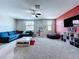 Spacious living room with blue couch, large tv, and neutral carpet at 2798 Hilliard Dr, Wesley Chapel, FL 33543