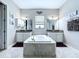 Luxurious main bathroom featuring dual vanities, a soaking tub, and modern fixtures for a spa-like experience at 2798 Hilliard Dr, Wesley Chapel, FL 33543
