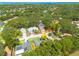 Aerial view showcasing the home's location within a lush, tree-filled neighborhood near a lake and the sea at 310 Arbor E Dr, Palm Harbor, FL 34683