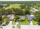 Elevated aerial view of the residence highlighting its spacious lot, manicured lawn, and proximity to a sports field at 310 Arbor E Dr, Palm Harbor, FL 34683