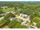Aerial view featuring the property nestled among lush greenery in a residential neighborhood near a small lake at 310 Arbor E Dr, Palm Harbor, FL 34683