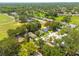Overhead view of a neighborhood with tree-lined streets, green space, and single-Gathering homes at 310 Arbor E Dr, Palm Harbor, FL 34683