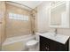 Bright bathroom featuring a shower-tub combo, tiled walls, and a modern vanity at 310 Arbor E Dr, Palm Harbor, FL 34683