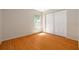 Clean, empty bedroom with hardwood floors, a window, and double closet doors at 310 Arbor E Dr, Palm Harbor, FL 34683
