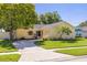 Charming single-story home with a well-maintained lawn, mature trees, and a welcoming driveway at 310 Arbor E Dr, Palm Harbor, FL 34683