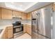 Well-equipped kitchen with stainless steel appliances including range, hood, and refrigerator at 310 Arbor E Dr, Palm Harbor, FL 34683