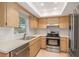 Updated kitchen with stainless steel appliances, light wood cabinets and a double sink at 310 Arbor E Dr, Palm Harbor, FL 34683