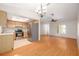 Kitchen and dining space featuring stainless steel appliances, hardwood floors, and modern lighting at 310 Arbor E Dr, Palm Harbor, FL 34683