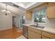 Bright kitchen featuring stainless steel appliances, a double sink, and slider doors to the backyard at 310 Arbor E Dr, Palm Harbor, FL 34683