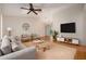 Bright living room featuring modern furniture, a ceiling fan, and hardwood floors at 310 Arbor E Dr, Palm Harbor, FL 34683