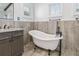 Elegant bathroom featuring a freestanding tub with vintage-style fixtures and wood-look accent wall at 311 12Th N Ave, St Petersburg, FL 33701