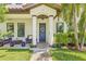 Charming front porch with seating, manicured lawn, and a welcoming blue door at 311 12Th N Ave, St Petersburg, FL 33701