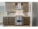 Close up of a kitchen featuring a stainless steel range with hood, granite countertops, and patterned backsplash at 311 12Th N Ave, St Petersburg, FL 33701